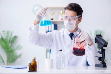 Hastane kliniğinde kan örnekleriyle çalışan bir doktor.