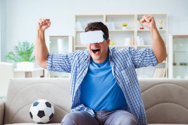 Sanal gerçeklik gözlüğü takan bir adam futbol maçı izliyor.