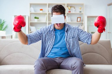 Sanal gerçeklik gözlüğü takan adam boks oyunu oynuyor.