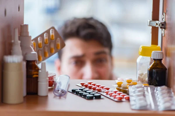 Malato in cerca di medicinali a scaffale farmacia — Foto Stock