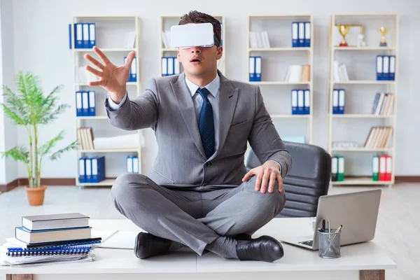 Affärsman i virtuell verklighet VR-glasögon mediterar högst upp på skrivbordet — Stockfoto