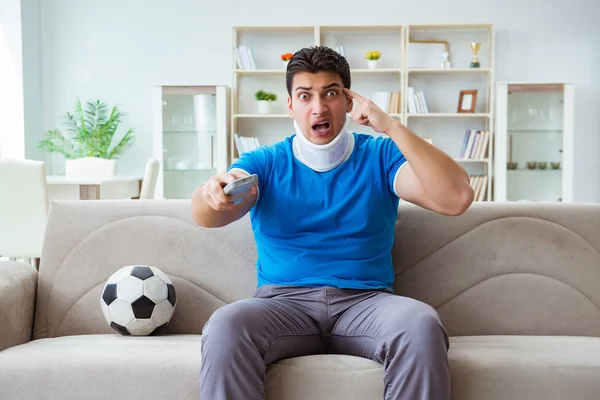 Hombre con lesión en el cuello viendo fútbol fútbol en casa —  Fotos de Stock