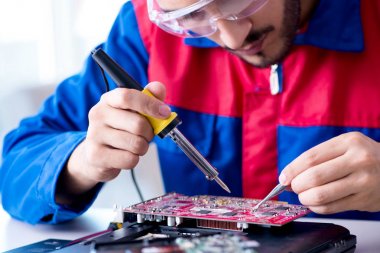 Bilgisayar dizüstü bilgisayarının tamirinde çalışan tamirci.