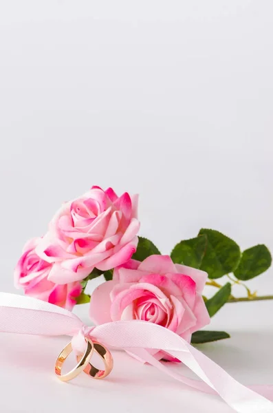 Svatební koncept s prsteny a růžemi — Stock fotografie