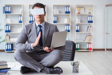 Sanal gerçeklikteki iş adamı VR gözlükleri masanın üstünde meditasyon yapıyor.