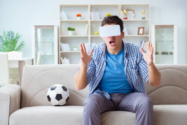 Sanal gerçeklik gözlüğü takan bir adam futbol maçı izliyor.