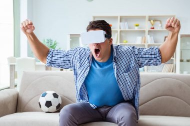 Sanal gerçeklik gözlüğü takan bir adam futbol maçı izliyor.