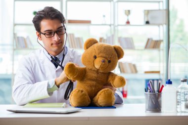 Ofiste oyuncaklı bir çocuk doktoru oturuyor.