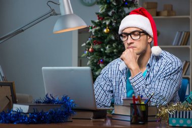 Genç adam Noel günü evde çalışıyor.