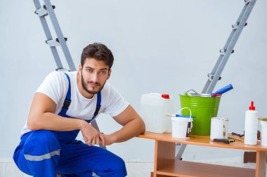 Tamirci, duvar kağıdıyla evde tadilat yapıyor.