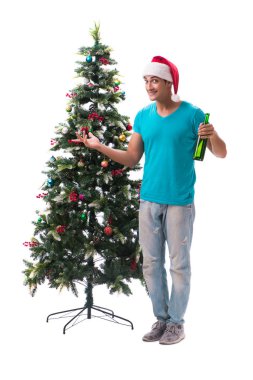 Genç adam beyaz üzerine izole edilmiş noel ağacını süslüyor.