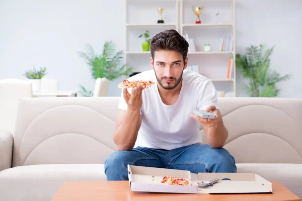 Hombre comiendo pizza teniendo una comida para llevar en casa descansando relajado —  Fotos de Stock