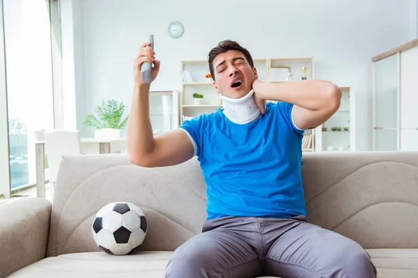 男子颈部受伤在家看足球 — 图库照片