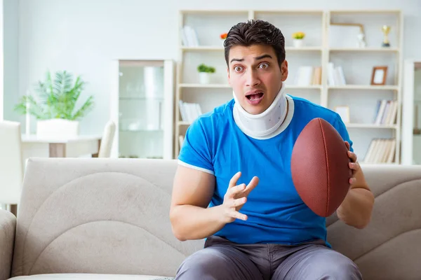 Mann mit Nackenverletzung schaut American Football zu Hause — Stockfoto