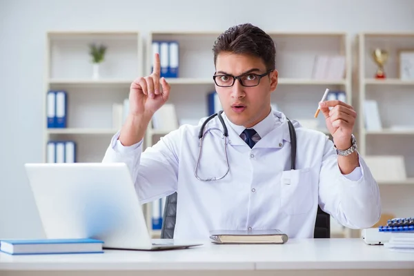 Médico masculino en concepto anti-tabaquismo con paquete de cigarrillos — Foto de Stock