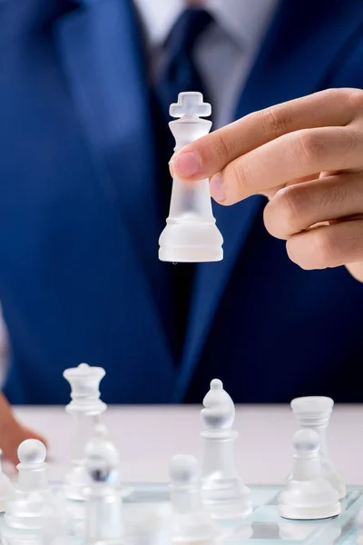 Young businessman playing glass chess in office — Stock Photo, Image