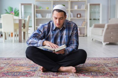 Genç Müslüman adam evde dua ediyor.