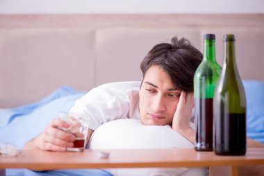 Yatakta içen alkolik adam depresyona giriyor.