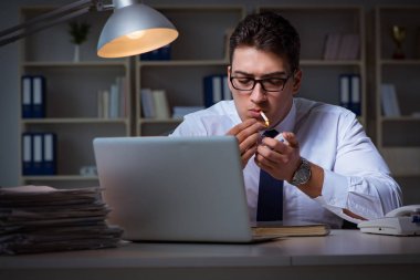 Stres altındaki iş adamı ofiste sigara içiyor
