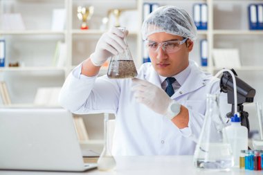 Genç araştırmacı bilim adamı bir su testi kirliliği araştırması yapıyor.