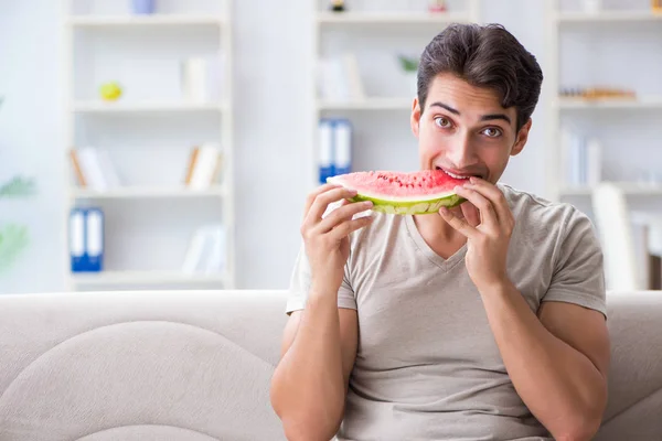 Ο άνθρωπος τρώει καρπούζι στο σπίτι — Φωτογραφία Αρχείου