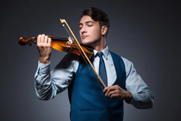 Young man playing violin in dark room — Stock Photo, Image