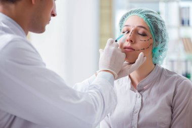 Estetik cerrah kadın yüzü ameliyatına hazırlanıyor