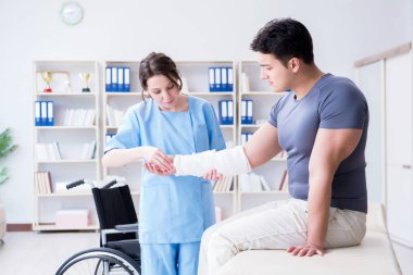 Hastanede yaralanma kontrolü sırasında doktor ve hasta.