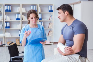 Hastanede yaralanma kontrolü sırasında doktor ve hasta.