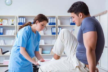 Hastanede yaralanma kontrolü sırasında doktor ve hasta.