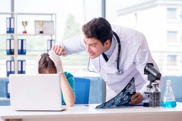 Dwóch lekarzy omawiających zdjęcie rentgenowskie w szpitalu. — Zdjęcie stockowe