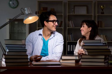 İki öğrenci geç saatlere kadar çalışıp sınavlara hazırlanıyor.