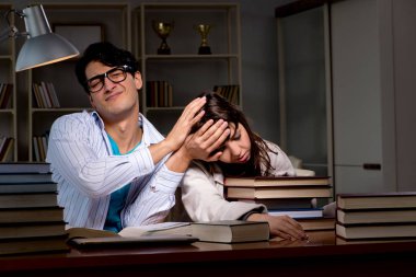 İki öğrenci geç saatlere kadar çalışıp sınavlara hazırlanıyor.