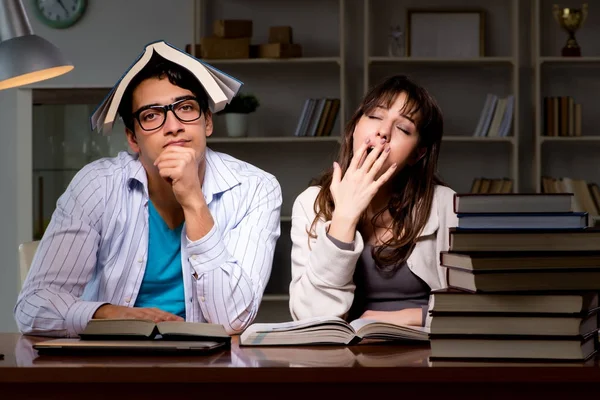 İki öğrenci geç saatlere kadar çalışıp sınavlara hazırlanıyor.