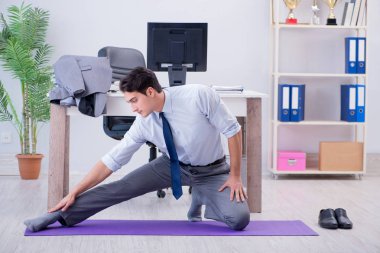 İş adamı tatilde ofiste spor yapıyor.