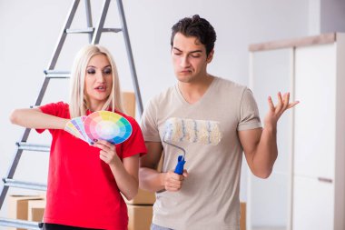 Ev tadilatı sırasında genç bir aile boya işi yapıyor.