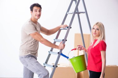 Ev tadilatı sırasında genç bir aile boya işi yapıyor.