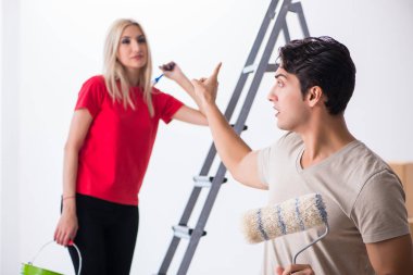 Ev tadilatı sırasında genç bir aile boya işi yapıyor.