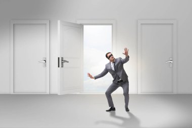 Kapıların önünde kafası karışmış bir iş adamı.