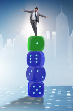 İş adamı belirsizlik içinde zar yığınının üzerinde dengede duruyor