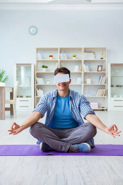 Мужчина в очках виртуальной реальности медитирует на полу в центре — стоковое фото