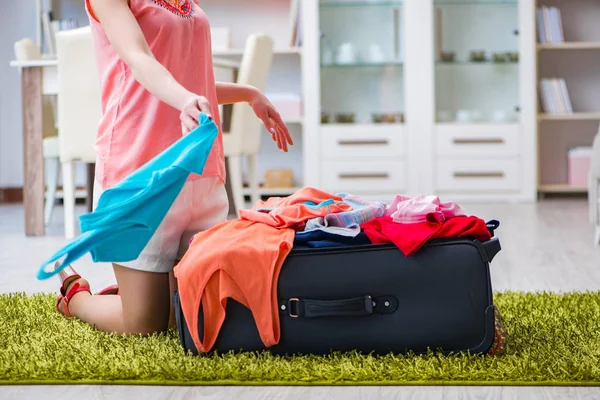 Tatilden önce bütün giysileri bavula sığdırmaya çalışan kadın. — Stok fotoğraf
