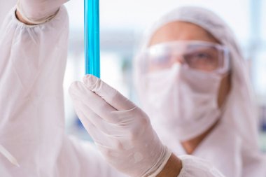 Laboratuvarda zehirli kimyasallarla çalışan bir kimyager.