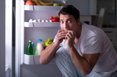Buzdolabındaki adam gece yemek yiyor.