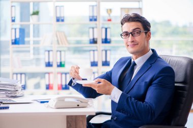 İş adamı tatilde ofiste kahve içiyor.