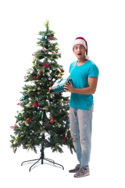 Genç adam beyaz üzerine izole edilmiş noel ağacını süslüyor.
