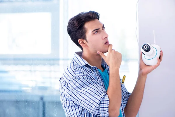 Man installing surveillance CCTV cameras at home