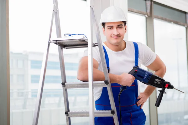 Riparatore che lavora con trapano elettrico in officina — Foto Stock