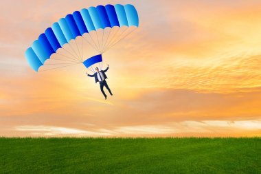 Genç işadamı iş konseptinde paraşütle atlıyor