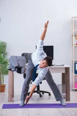 İş adamı tatilde ofiste spor yapıyor.